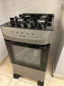 a stove top oven sitting in a kitchen at Kitnet em Americana SP in Americana +18 photos