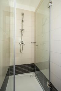 a shower with a glass door in a bathroom at Hotel National in Zagreb