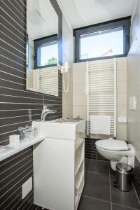 a white bathroom with a sink and a toilet at Hotel National in Zagreb