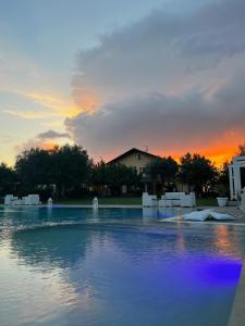 a pool of water with a sunset in the background at Tenuta Paino in Sessa Aurunca