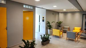an office lobby with yellow chairs and tables at Unity Hotel - Sorocaba in Sorocaba