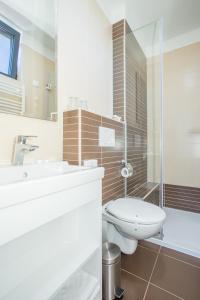 a bathroom with a toilet and a sink and a shower at Hotel National in Zagreb