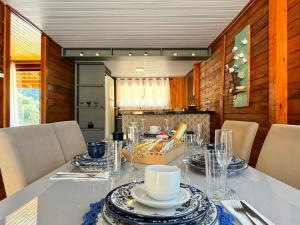 a dining room with a table with dishes on it at Sítio Raizes da Videira - SRR004 in Pinheiral