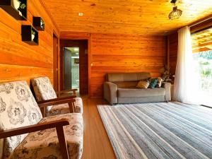 a living room with two chairs and a couch at Sítio Raizes da Videira - SRR004 in Pinheiral