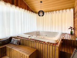a bath tub sitting in a room with a wooden wall at Sítio Raizes da Videira - SRR004 in Pinheiral +28 photos