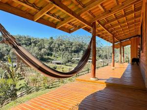 a hammock on the porch of a house at Sítio Raizes da Videira - SRR004 in Pinheiral