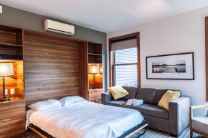 a bedroom with a bed and a couch at Lakefront Mountain View - Resort Studio in Lac-Superieur