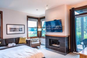 a bedroom with a fireplace and a tv on a wall at Lakefront Mountain View - Resort Studio in Lac-Superieur