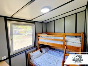 two bunk beds in a small room with a window at Florianówka- Nocleg i Spa na Roztoczu in Narol