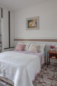 Schlafzimmer mit einem Bett mit rosa und weißer Bettwäsche in der Unterkunft Suite Casal Mar e Lua em casa compartilhada in Ubatuba