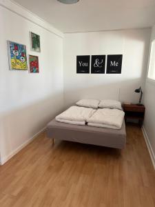 a bed in a room with pictures on the wall at Lejlighed - med mulighed for Fitness in Nakskov