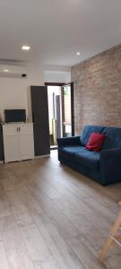 a living room with a blue couch and a brick wall at La Corte di Nonno Gino in Stresa