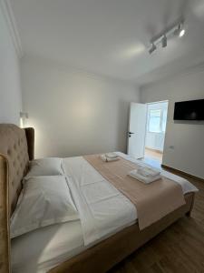 a white bedroom with a large bed with white sheets at Nord 22 in Constanţa +59 photos