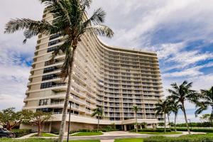 een hoog gebouw met palmbomen ervoor bij 2 BR Condo by the Beach - Splendid Ocean View in Marco Island