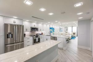 een keuken met witte kasten en roestvrijstalen apparaten bij 2 BR Condo by the Beach - Splendid Ocean View in Marco Island