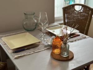 a dining room table with a white table with glasses at Idéal couple & pro centre calme, wifi, proche gare in Lamballe +14 photos