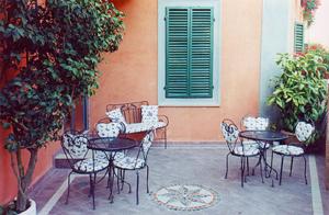 a patio with tables and chairs in front of a building at Villa Le Camelie Siena in Siena +45 photos