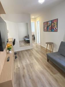 a living room with a blue couch and a television at Apartamento Inteiro Novo - 2 Quartos - REGIÃO CENTRAL FOZ in Foz do Iguaçu