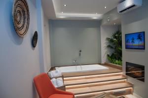a bathroom with a bathtub and a chair and a tub at Secret Heaven JK in Ioannina