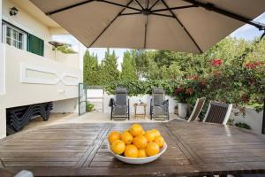 a bowl of oranges on a wooden table with an umbrella at Villa Nascente Balaia in Branqueira