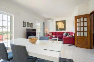 a living room with a white table and a red couch at Villa Nascente Balaia in Branqueira