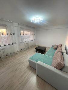 a living room with a couch and a table at Самрук Towers,жилой комплекс in Taldykolʼ