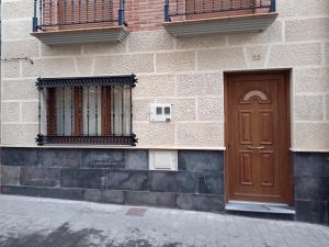 a building with a brown door and a window at Casa Puente Rioja in Cenicero