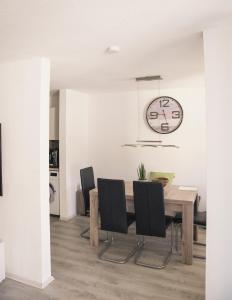 a dining room with a table and chairs and a clock at AllgäuBrise in Sonthofen +2 photos