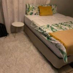 a bedroom with a bed and a small table at Alvin ‘s House in Tsumeb +8 photos