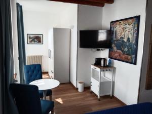 a small living room with a table and a tv at Suite Coccinella in Udine