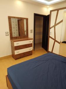 a bedroom with a bed and a dresser and a mirror at شقة مفروشة Furnished apartment in 6th Of October
