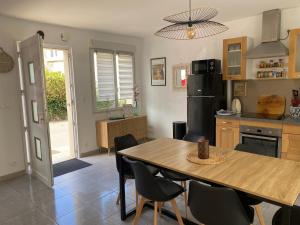 a kitchen with a table and chairs and a refrigerator at Petit Coin du Port in Ploubazlanec