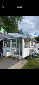 a white house with a porch and a deck at Ölandspärlan 2 in Färjestaden