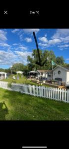 a white fence in front of a yard with a house at Ölandspärlan 2 in Färjestaden