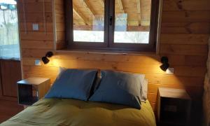a bedroom with a bed with a window and two tables at La kuruxa apartamento in Arronte