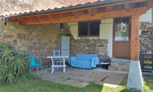 a patio with a blue couch and chairs and a table at La kuruxa apartamento in Arronte