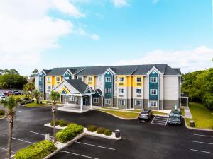 an apartment building with a parking lot at The Windstar Hotel - Carolina Beach in Carolina Beach
