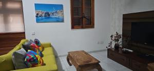 a living room with a yellow couch and a tv at Villa on Sliema Promenade and ferries in Sliema