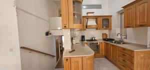 a kitchen with wooden cabinets and stainless steel appliances at 3 Floors Villa on Promenade 4 bedrooms 3 bathrooms V1 in Sliema