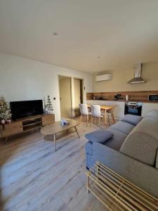 una sala de estar con un sofá y una mesa en superbe logement privatif à côté de la via Rhona, en Charmes-sur-Rhône
