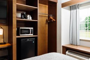 a room with a bed and a microwave and a window at The Windstar Hotel - Carolina Beach in Carolina Beach