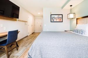 a bedroom with a large bed and a desk at The Windstar Hotel - Carolina Beach in Carolina Beach