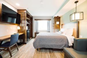a hotel room with a bed and a desk at The Windstar Hotel - Carolina Beach in Carolina Beach