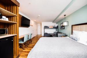 a hotel room with a bed and a living room at The Windstar Hotel - Carolina Beach in Carolina Beach