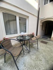 a patio with two chairs and a glass table at Chic Central Studio in Sibiu