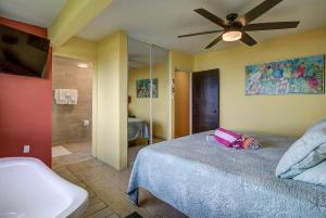 una camera da letto con un letto e un ventilatore a soffitto di Villa Marbella - Ocean Views & Private Pool a Luquillo Altre 32 foto