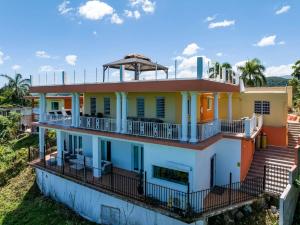 a house with a balcony on top of it at Villa del Enseuno- Pristine View and Infinity Pool in Luquillo