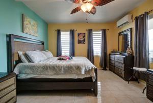 a bedroom with a bed and a ceiling fan at 3 Villas with Stunning Views & 2 Private Pools in Luquillo +256 photos