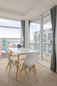 a dining room with a table and chairs and a large window at Harbor View Two Bedroom Apartment At Pinnacle in Wellington