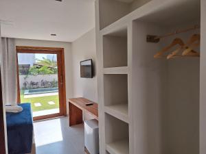 una stanza con scaffali e una porta con finestra di Pousada Oasis dos Ventos - São Miguel do Gostoso a São Miguel do Gostoso
